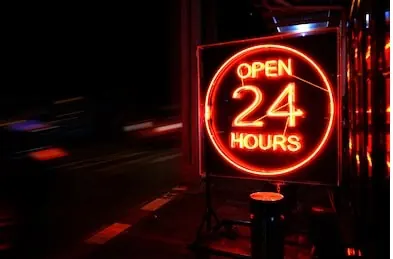 Cartel de neón con la leyenda Open 24 hours, que representa el servicio de fletes las 24 horas